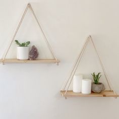 two wooden shelves with candles and plants on them