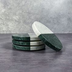 three green marble coasters stacked on top of each other in front of a gray background