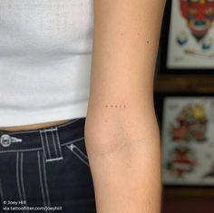 a woman's arm with an arrow tattoo on the left side of her arm