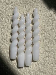 four white plastic toothbrush heads sitting on top of a carpeted floor next to each other