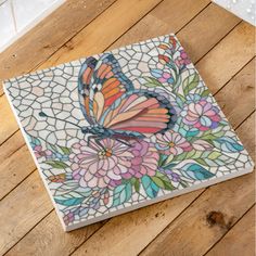 a colorful butterfly sitting on top of a wooden floor