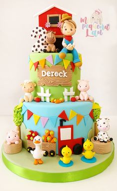 there is a cake decorated with farm animals on the top and around it are chickens, ducks, pigs, and a barn