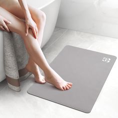 a woman sitting on a bathtub with her feet propped up