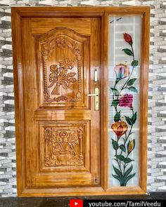 the wooden door is decorated with flowers and leaves on it's glass paneling