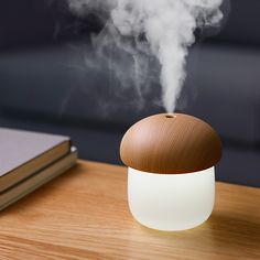 an aroma diffuser sitting on top of a wooden table