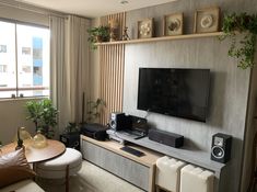 a flat screen tv sitting on top of a wooden entertainment center in a living room