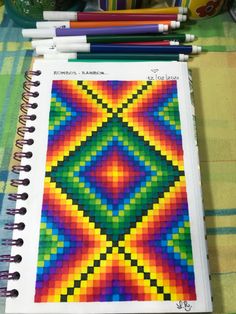 an open notebook with colored pencils on top of it next to some other items