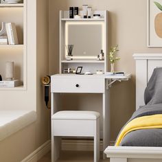 a bedroom with a white vanity table and stool next to a mirror on the wall