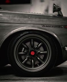 the front end of a car with black rims and red brake pads on it