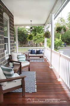 a porch with chairs and rugs on it