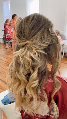 the back of a woman's head with long hair in a half - updo