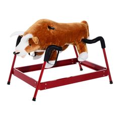 a stuffed cow laying on top of a red stand