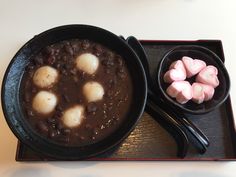 a black bowl filled with stew and marshmallows