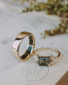 two wedding rings sitting on top of a piece of paper