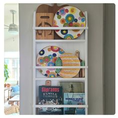 a white shelf filled with plates and books