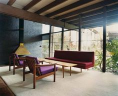 a living room with two couches and a table in front of large glass windows