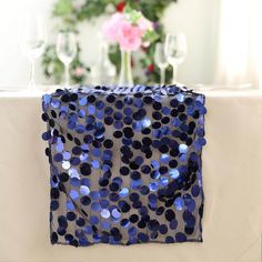 the table cloth has blue sequins on it and is next to wine glasses