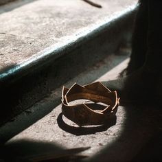 a wooden bracelet sitting on top of a cement floor