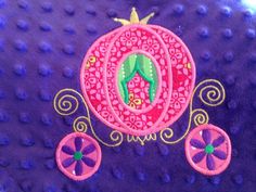 an embroidered horse drawn carriage on purple fabric