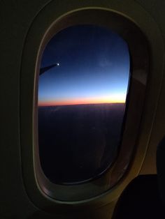 the view from an airplane window at sunset