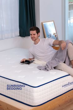 a man sitting on top of a white mattress