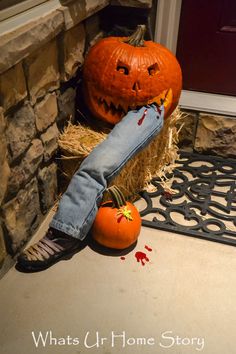 a pumpkin sitting on top of hay next to a person's leg wearing jeans