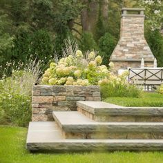 stone steps lead up to an outdoor fireplace