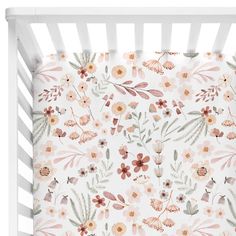 a white crib with pink and orange flowers on it