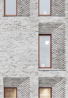 the side of a building with multiple windows and brickwork on it's sides