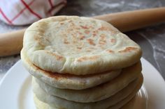 a stack of pita bread sitting on top of a white plate