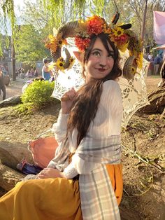 a woman with long hair sitting on the ground