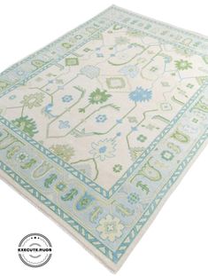 a white rug with blue and green designs on it's sides, in front of a