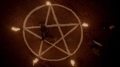 an overhead view of a pentagram surrounded by candles