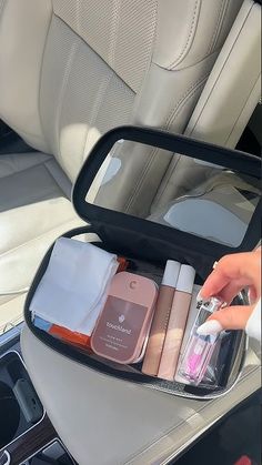 the inside of a car with an open suitcase containing cosmetics and personal care items in it