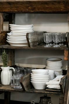 an old wooden shelf filled with dishes and glasses