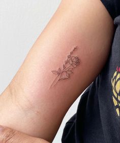 a woman's arm with a small flower tattoo on the left side of her arm