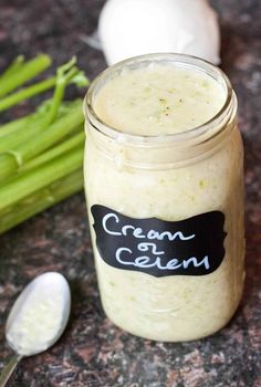 a jar filled with cream sitting on top of a counter next to green beans and onions