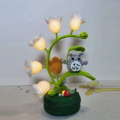 a crocheted plant with two stuffed animals on it's leaves and flowers