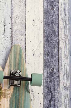 a skateboard is leaning against a wooden wall