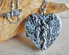 Fairy music box pendant. This heart shaped music box pendant is inspired by the gorgeous music box pendants of era's gone by. Music box is pill box size, please look at the dimensions for exact size. A perfect silver tone heart locket has been adorned with a layer of filigree and silver fairy with purple rhinestone on her wings. The filigree and fairy have been finished with resin to preserve the beauty of this pendant. The music box winds from a key on the back of the pendant. The pendant hangs Fairy Music, Music Box Locket, Heart Shaped Locket, Silver Fairy, Saint Helens, Magical Accessories, Unique Handcrafted Jewelry, Simple Hoop Earrings, Round Locket