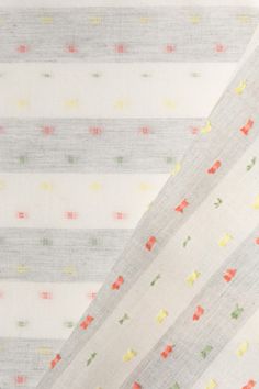 three pieces of white fabric with multicolored dots and stripes on the bottom half