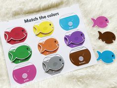 the match the colors fish magnets are displayed on a white sheet with fuzzy fur