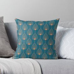 a blue and gold throw pillow sitting on top of a couch