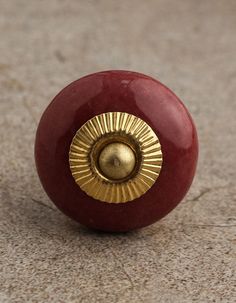 a close up of a red object on the ground with a gold decoration around it