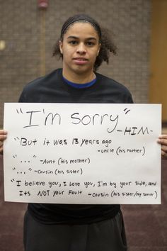 a woman holding up a sign that says i'm sorry