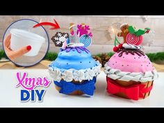 two cupcakes are decorated with colorful icing and decorations on top of each other