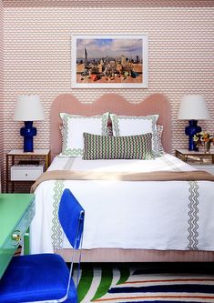 a bedroom with a bed, two nightstands and pictures on the wall above it