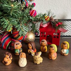 a group of small figurines sitting next to a christmas tree