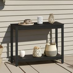 an outdoor table with baskets and vases on it