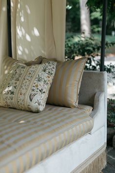 a bed with two pillows on top of it next to a canopy over the bed